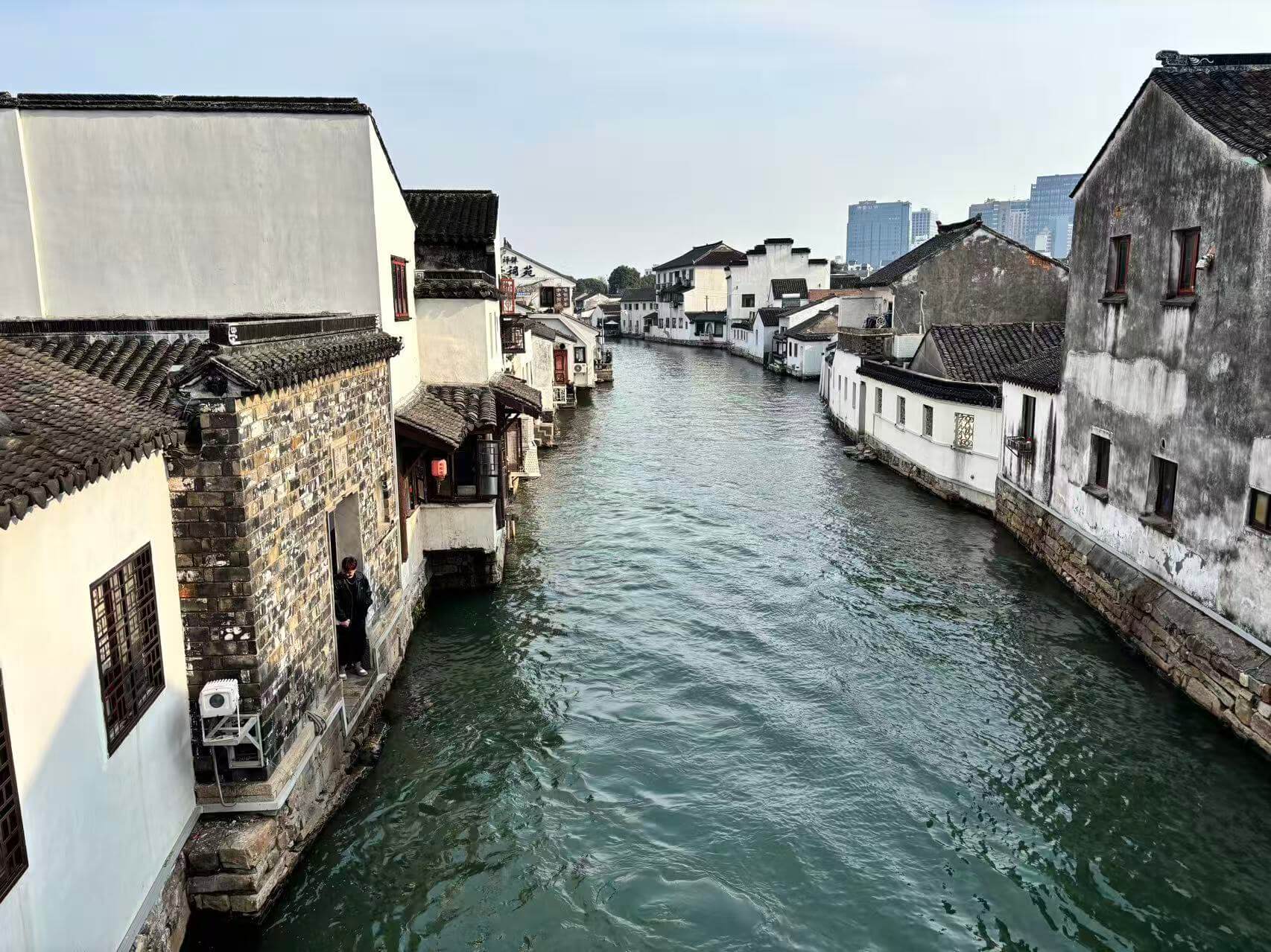 White walls, dark tiles and houses at the water’s edge.